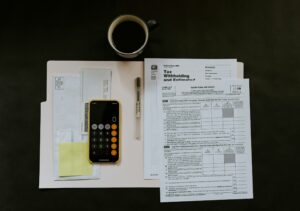 Merchant reading a credit card processing statement with calculator and pen analyzing fees