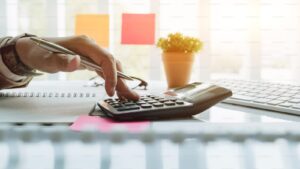 Close up view of bookkeeper or financial inspector hands making report, calculating or checking balance. Home finances,